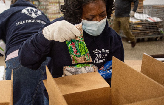 Volunteers pack pinto beans, tortillas, masa flour, and other food staples for distribution